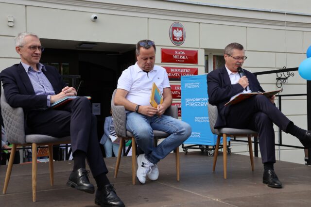 Mężczyźni czytający przed ratuszem dzieciom bajki