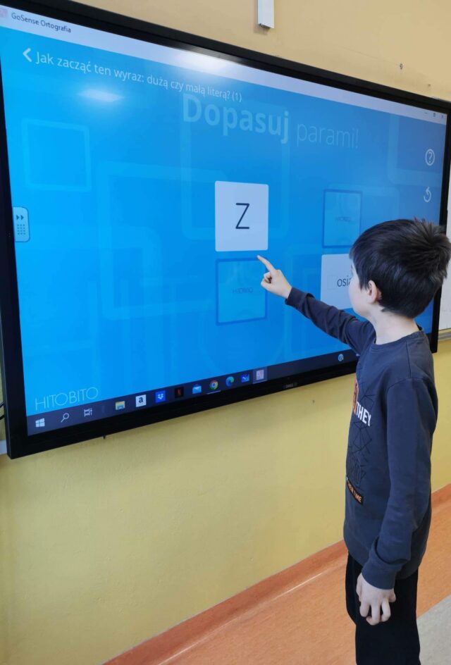dziecko korzystające z interaktywnej tablicy, która pomaga w przyswajaniu wiedzy