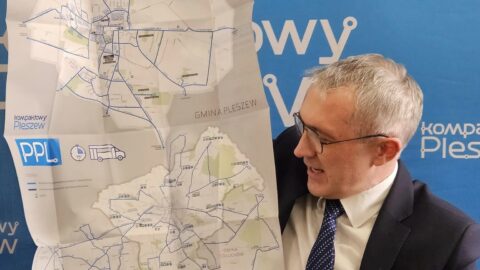 burmistrz MiG Pleszew trzymający mapę z nowymi rozkładami jazdy komunikacji publicznej.