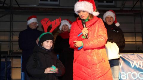 Prowadząca wydarzenie wraz z burmistrzem Pleszewa i zastępcami i dziewczynką wylosowaną do odpalenia świątecznych dekoracji w Pleszewie na Rynku.